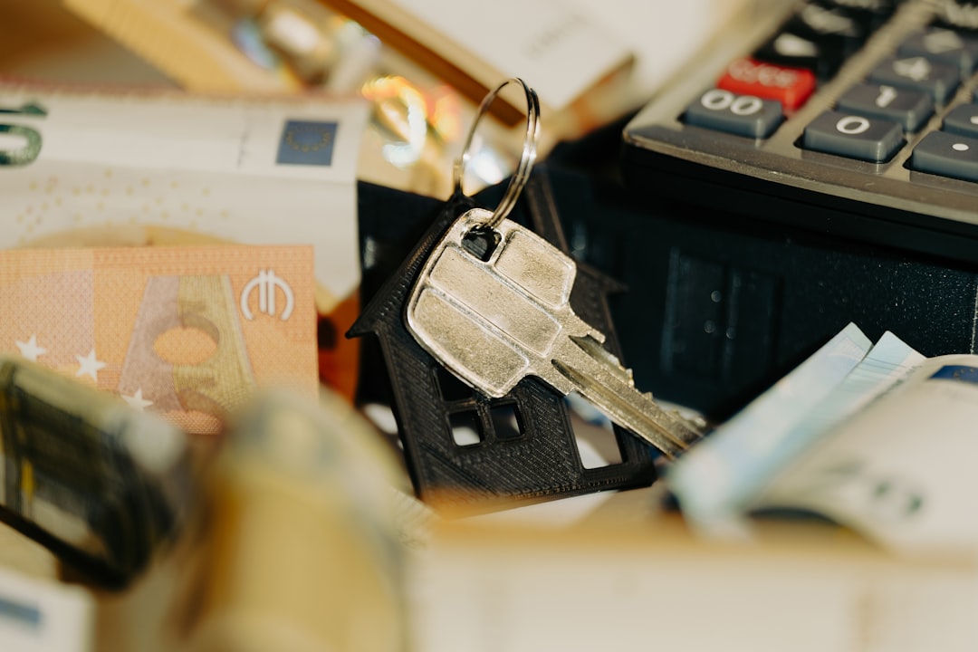 A close-up shot of a person's hand holding a set of house keys and a thick stack of cash, symbolizing the equity saved by avoiding high commission fees.