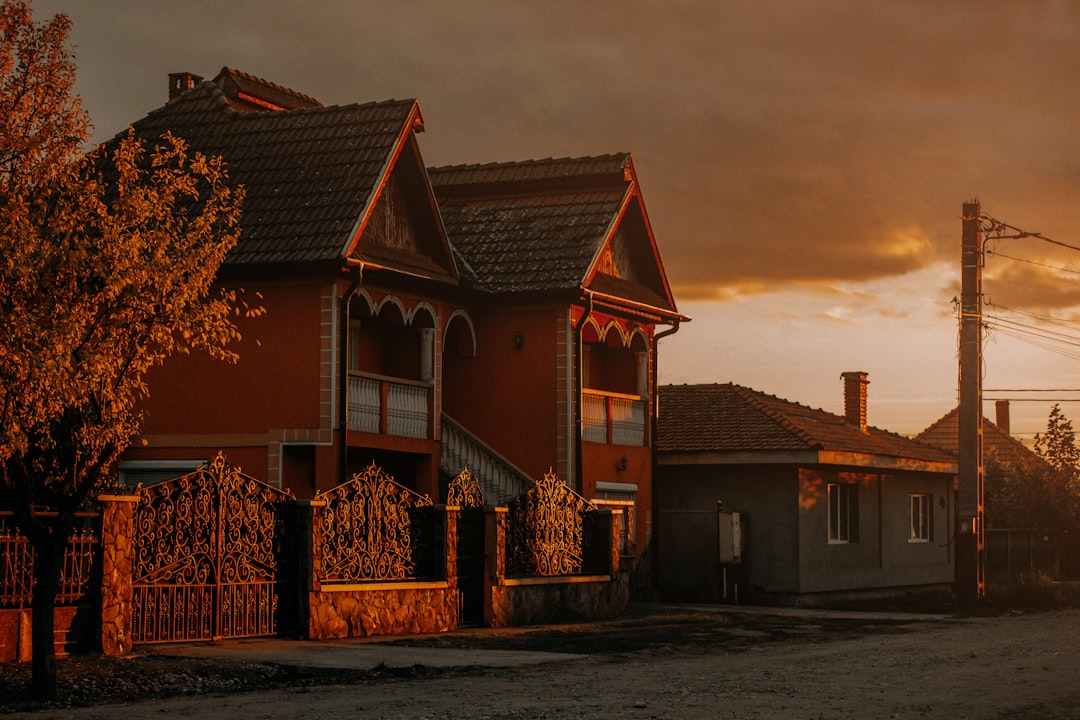 A single, modern suburban house sits alone on an empty street under a clear sky, symbolizing a stale listing that has been overlooked by buyers.