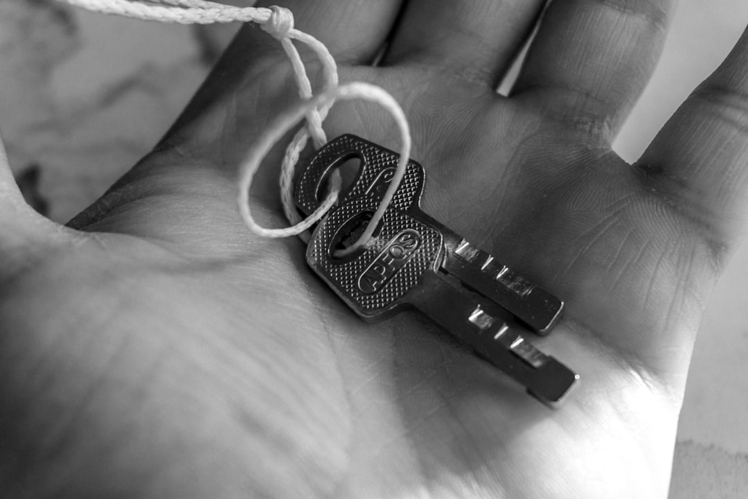 A close-up shot of a real estate agent's hand giving a set of house keys to a new homeowner, symbolizing a successful and completed property sale.