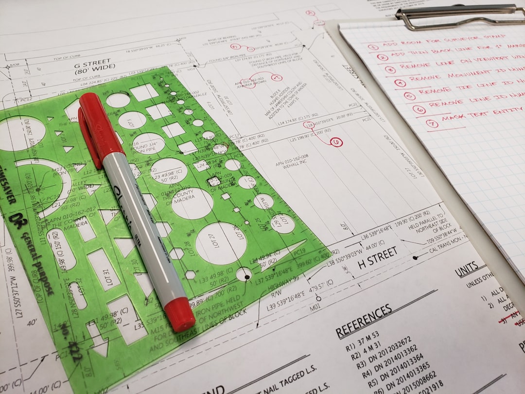 A flat lay of architectural blueprints and a calculator on a clean, modern desk, symbolizing the transparent, full-service approach to real estate.
