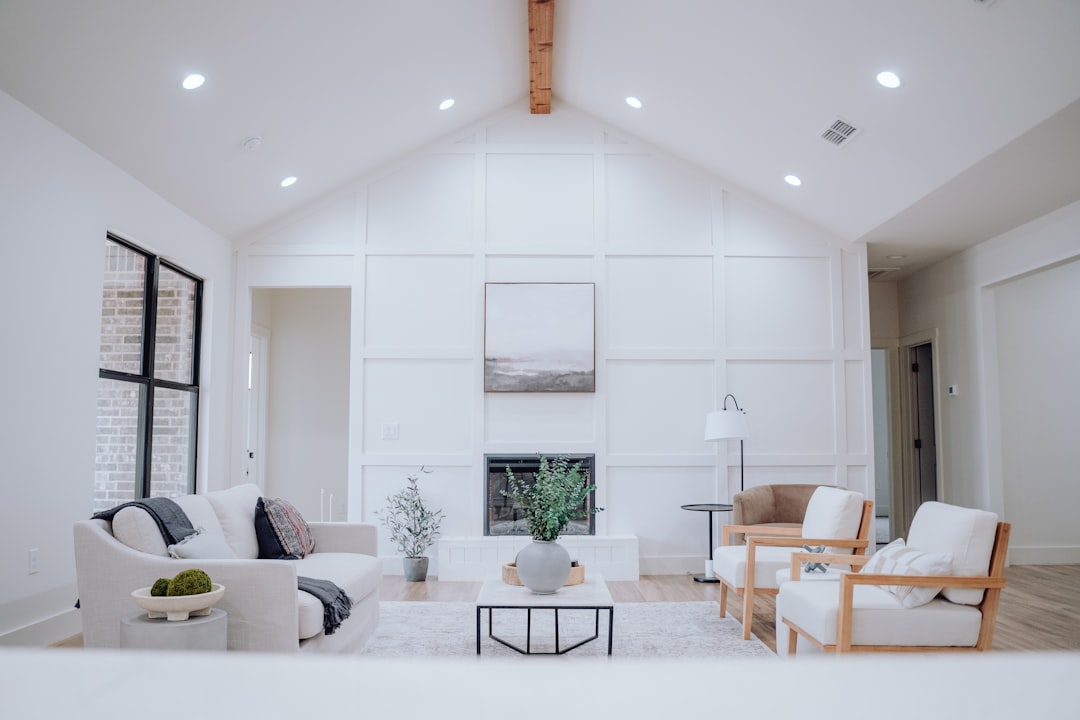A professional real estate agent warmly consulting with a smiling couple in a bright, stylish living room, showcasing a positive full-service client relationship.