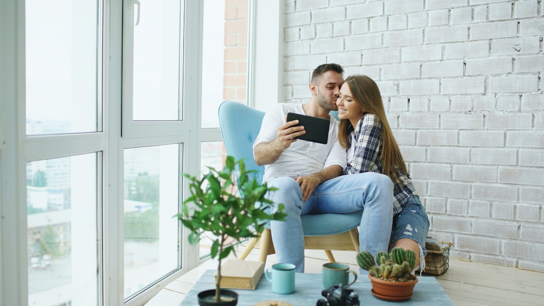 A professional real estate agent guiding potential buyers through a bright and modern living room, illustrating successful buyer agent traffic.