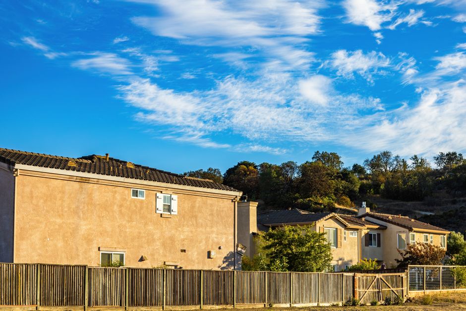 Modern suburban street in Castle Rock, Colorado, with beautiful homes under a bright blue sky, representing the local real...