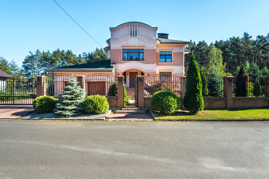 A clean, professional shot of a street in a modern and affluent suburban neighborhood on a bright, sunny day, representing the desirable Castle Rock community.